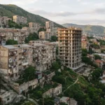 Жилые дома на склоне в Тбилиси, среди них недостроенное здание